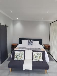 a bedroom with a large bed with two pillows at bird haven self catering in Donny-brook