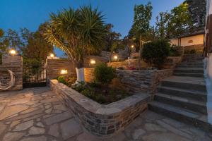 una escalera de piedra que conduce a una casa con luces en Anemoesa, en Batsi