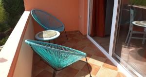 two green chairs sitting on a patio with a table at Apartmani Tanja in Tivat