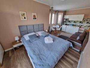 Un dormitorio con una gran cama azul y un sofá en Willa Zachodni Brzeg, en Międzyzdroje