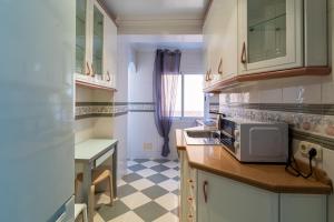 eine kleine Küche mit einer Mikrowelle und einem Tisch in der Unterkunft Trendy Homes El Puerto de Almería- Muy próximo Playa y Centro Wifi gratis in Almería
