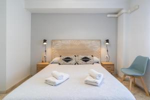 a bedroom with a bed and a blue chair at TrendyHomes El Puerto de Almería, próximo Playa y Centro,3 HAB, Espacioso, Familias, Wifi in Almería +31 photos
