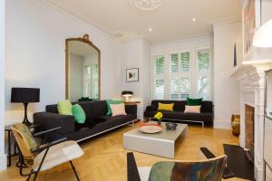 a living room with a black couch and a mirror at Veeve - Classical Graffiti in London