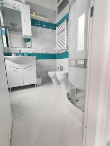 La salle de bains blanche est pourvue d'un lavabo et de toilettes. dans l'établissement Casa Vacanze Da Serena, à Ischia