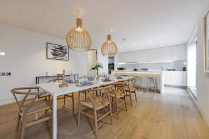 a kitchen and dining room with a long table and chairs at Stayo Apartments Southbank in London