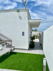 a white house with a yard of green grass at Katy's Holiday House, Private Villa in Terrasini