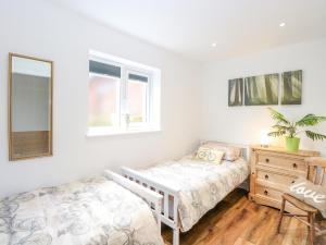 una camera con letto, cassettiera e specchio di Walnut Shade ad Attleborough
