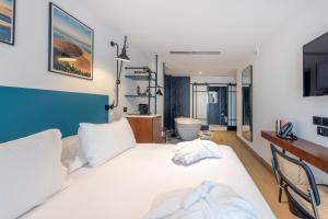 Victoria Boutique Hotel في أركاشون: غرفة نوم بسرير ابيض وحمام