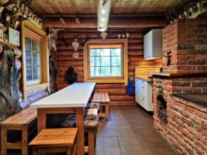 eine Küche mit einem Tisch und einem gemauerten Kamin in der Unterkunft Haudamäe Puhkemaja in Meelva