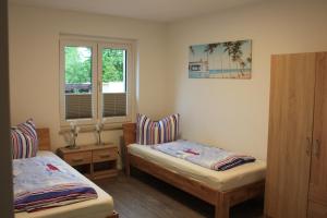 a bedroom with two beds and a window at Ferienwohnungen Wassergrundstück Malchow in Malchow