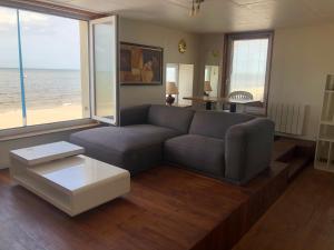 a living room with a couch and a view of the ocean at Villa ALOHA in Bray-Dunes