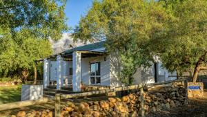 a white house with a fence and trees at Welbedacht Game & Nature Reserve in Tulbagh