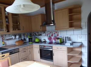 a kitchen with wooden cabinets and a stove top oven at Ferienwohnung Hagebuttenweg in Thale