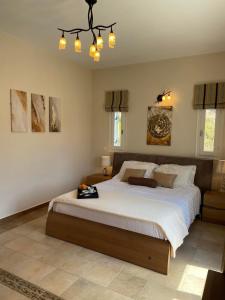 a bedroom with a large bed and a chandelier at SUNSENSES Villa in Angairiá
