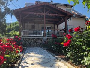 uma casa com um alpendre com flores vermelhas em Kishableány Apartmanház em Badacsonytomaj