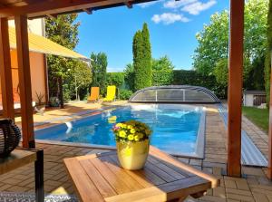 a patio with a pool and a table with a flower pot at Canadian style house with 3D effect pool in Vinosady