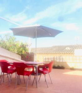 una mesa y sillas con una sombrilla en el patio en EL NIU DE LA BERTA, en Bellcaire dʼEmpordà