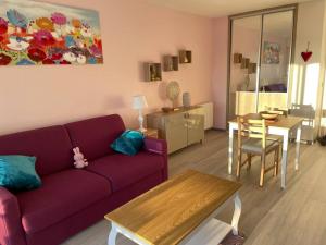 a living room with a purple couch and a table at Petit Studio Zen avec parking gratuit réservé in Houlgate