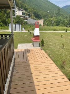 a wooden deck with a red and white lighthouse on it at BISER KVARNERA 1. in Mošćenička Draga