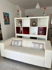 een witte bank met 2 kussens in de woonkamer bij "Da Vittorio" Armony House in Pescara