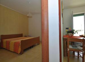 a bedroom with a bed and a table in a room at Gallipoli Mancaversa Futura Vacanza Andrea in Marina di Mancaversa