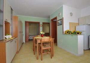 a kitchen with a table and a kitchen with a refrigerator at Gallipoli Mancaversa Futura Vacanza Andrea in Marina di Mancaversa