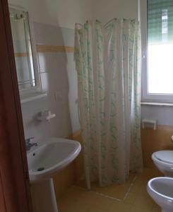 a bathroom with a sink and a shower curtain at Gallipoli Mancaversa Futura Vacanza Andrea in Marina di Mancaversa