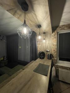 sala de estar con mesa de madera y 3 luces en Dzivoklis ar saunu en Rēzekne