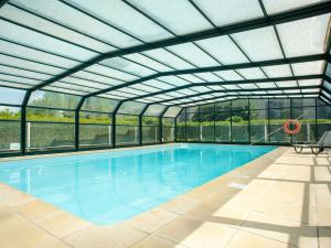 an indoor swimming pool with a glass roof at Vacancéole - Le Duguesclin in Dinan