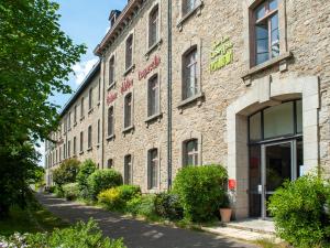 un grande edificio in mattoni con cespugli di fronte di Vacancéole - Le Duguesclin a Dinan