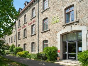a large brick building with a store front at Vacanc&eacute;ole - Le Duguesclin in Dinan