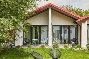 a group of chairs in the grass in front of a house at Sadova Park in Ślesin