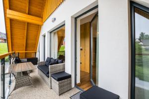 a patio with chairs and a table on a house at ApartHost Apartamenty Butorowy & Spa in Kościelisko