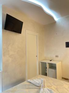 a bedroom with a bed and a flat screen tv on the wall at Narcisse in Tropea +23 photos