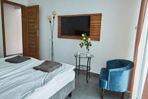 a bedroom with a bed and a table and a tv at Sadova Park in Ślesin