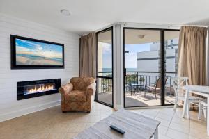 - un salon avec une cheminée et une chaise dans l'établissement Hosteeva 1-bedroom Meridian Plaza Condo with Ocean View, à Myrtle Beach