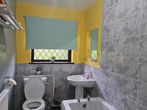 a bathroom with a toilet and a sink at Immaculate 3-Bed House in Middleton in Middleton