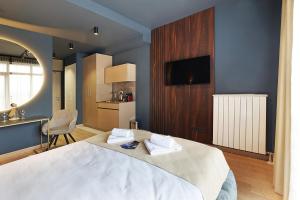 Cet appartement comprend une chambre avec un grand lit blanc et une cuisine. dans l'établissement Belgrade Waterfront Apartments - Arcadia, à Belgrade