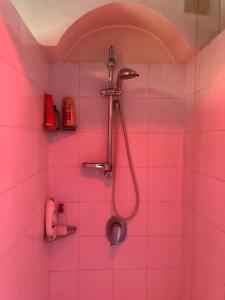 różowa łazienka z prysznicem z głowicą prysznicową w obiekcie Apartment with terrace in Milano navigli w Mediolanie