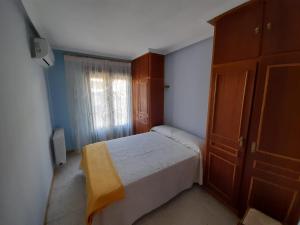 a small bedroom with a bed and a window at La casa del puerto in El Arenal