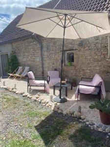 Creuzier-le-Neuf的住宿－Logement indépendant Piscine et Jardin，庭院配有两把椅子和一把遮阳伞