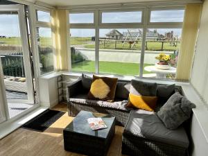 un soggiorno con un divano e una grande finestra di Beautiful Beach Front Cottage ad Allonby Altre 29 foto
