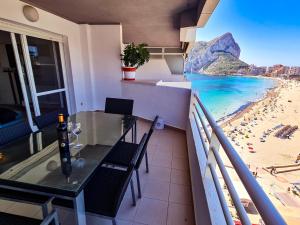 balkon ze stołem i krzesłami oraz plażą w obiekcie AVANOA - Esmeralda Calpe w mieście Calpe