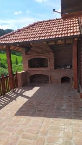 un padiglione in mattoni con un grande camino in un patio di Zaovinski Raj2 Tara a Konjska Reka