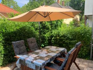 een tafel met een parasol en twee stoelen en een tafel met een tafel en stoelen bij Öböl Apartman in Balatonboglár