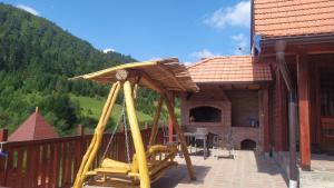 a porch of a house with a wooden swing at Zaovinski Raj2 Tara in Konjska Reka
