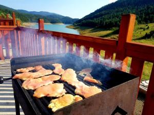 una griglia con carne sopra e vista sul lago di Zaovinski Raj2 Tara a Konjska Reka 1 altra foto