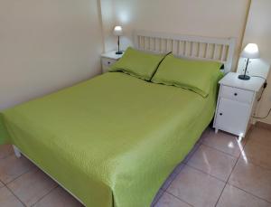 ein Schlafzimmer mit einem grünen Bett mit zwei Nachttischen in der Unterkunft Apartamento HAKUNA MATATA con gran terraza, planta baja in Playa de San Juan
