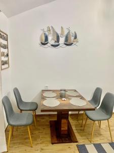 een eetkamer met een tafel en vier stoelen bij Öböl Apartman in Balatonboglár