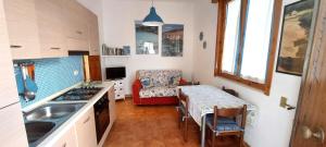 a kitchen with a table and a dining room at Casa vacanza Poesia in San Foca